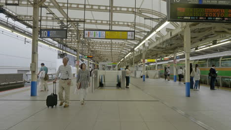 Tokyo-Japan---Circa-An-older-Asian-couple-walks-through-the-airport-looking-up-at-the-signs-for-directions