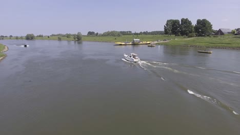 A-drone-shot-flying-sideways-to-the-left,-flying-over-a-river-with-multiple-boats-on-the-river