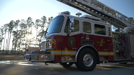 Fire-engine-sits-shiny-outside-of-a-fire-station-in-the-early-morning-sunlight