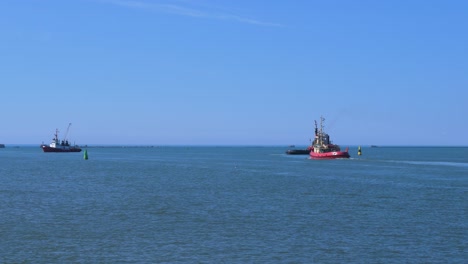 Harbour-tug-leaving-Port-of-Liepaja-in-hot-sunny-day,-wide-shot-from-a-distance