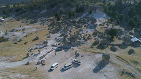 Aerial-pull-back-shot-of-El-Valle-de-los-Hongos-with-tourists-and-Raramuris-product-stands,-Copper-Canyon-Region,-Chihuahua