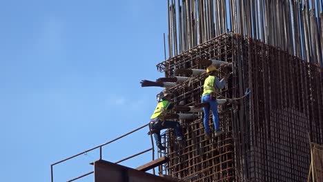 Bauarbeiter,-Die-In-Der-Höhe-Arbeiten-Und-Auf-Der-Baustelle-Stahlbewehrungsstäbe-Herstellen