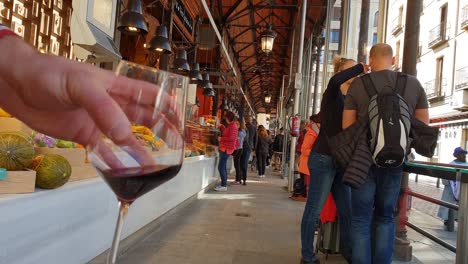 Enjoying-delicious-wine-at-Mercado-de-San-Miguel,-Plaza-Mayor,-Madrid