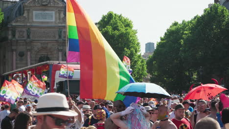 The-Gay-Pride-march-passing-by-with-a-person-holding-a-rainbow-flag