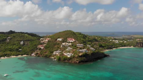 Vista-Aérea-épica-De-Casas-Construidas-En-Los-Acantilados-Con-Vistas-A-Una-Playa-Increíble-En-La-Isla-De-Las-Especias-De-Granada