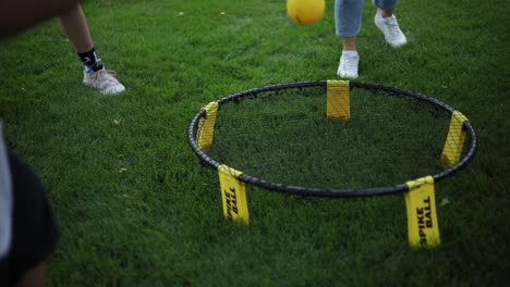 Un-Grupo-De-Niños-Está-Jugando-Al-Juego-Spikeball-Golpeando-La-Pequeña-Bola-Amarilla-En-La-Red