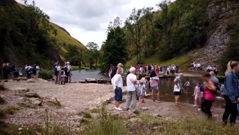 Timelapse-De-Stepping-Stones-De-Dovedale-En-Derbyshire,-Peak-District,-Inglaterra,-Reino-Unido,-Que-Muestra-Multitudes-De-Turistas-Cruzando-Los-Stepping-Stones-Sobre-El-Río-Dove