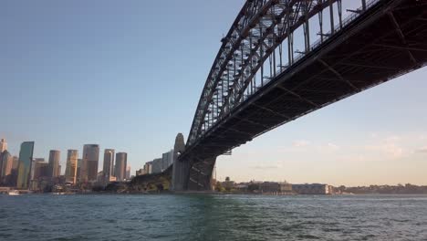 Wunderschönes-Schwenken-Und-Nahaufnahme-Der-Sydney-Harbour-Bridge-Unterhalb-Der-Brücke-Bei-Sonnenuntergang