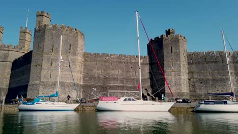 Caernarfon-Castle-Geschossen-Vom-Fluss-Seiont-Und-Zeigt-Die-Schlossfassade-Und-Den-Umliegenden-Tourismus-Und-Die-Boote