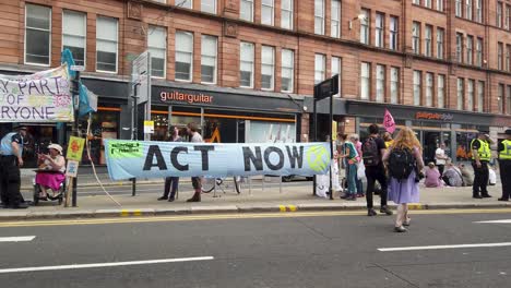 Demonstranten-Und-Polizisten-Der-Extinction-Rebellion,-Umgeben-Von-Transparenten,-Auf-Einer-Blockierten-Hauptstraße