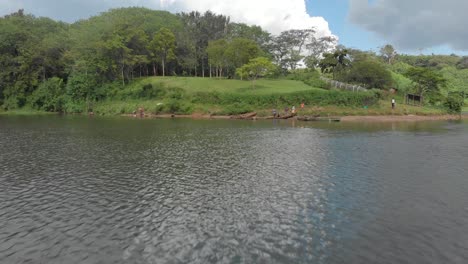 Una-Toma-Aérea-De-Bajo-Vuelo-A-Través-Del-Agua-Del-Río-Nilo-Y-Sobre-Un-Grupo-De-Pescadores-Africanos-Con-Sus-Tradicionales-Canoas-De-Madera