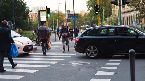 Pedestrians-crossing-the-street-during-evening-commute-in-Milan,-Italy