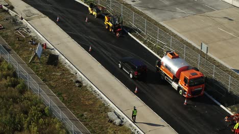 Close-aerial-shot-tracking-a-landrover-through-road-works-into-a-car-park