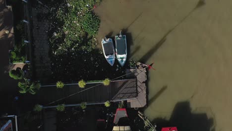 The-city-of-Can-Tho,-Vietnam-featuring-boats,-river,-and-architecture-from-drone-on-a-sunny-afternoon