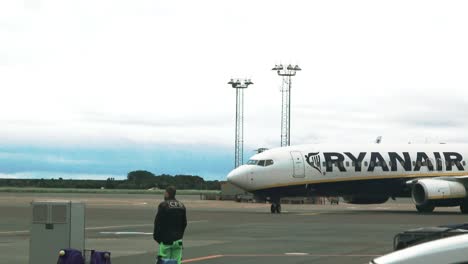 Avión-De-Ryanair-Acercándose,-Un-Trabajador-En-Primer-Plano