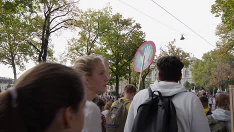 Crowd-of-protestors-slowly-moving-into-frame,-walking-on-street-during-fridays-for-future-climate-change-protests-in-Vienna,-Austria