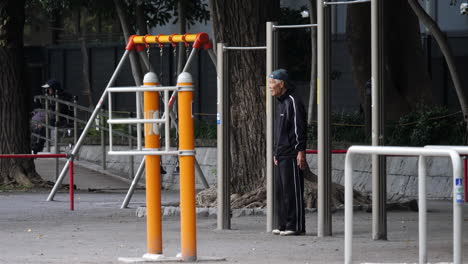 Slow-motion-of-japanese-old-man-resting-between-excercises-in-Ueno-Park,-Tokyo