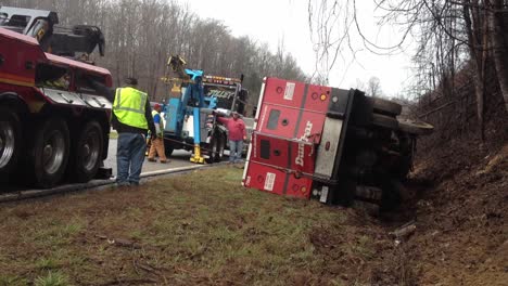 Wrecker-team-pulling-armored-car-from-ditch-after-wrecking-on-busy-highway