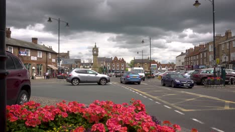 Thirsk,-North-Yorkshire-–-Langsamer-Verkehr-Und-Menschen,-Die-Auf-Dem-Marktplatz-Herumlaufen