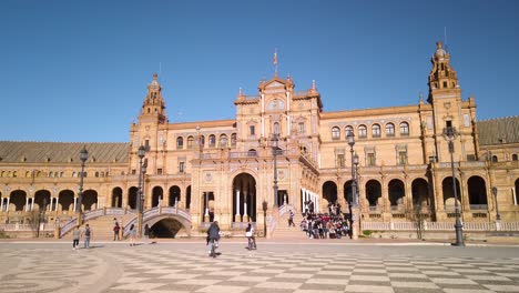 Tourists-gather-on-stairs-of-Plaza-de-Espana-in-Seville,-Spain,-Slowmo-Pan-Right