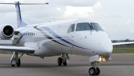 Close-up-of-an-aircraft-taking-a-left-turn-on-the-runway-preparing-for-takeoff-from-Maastricht-Aachen-Airport-on-a-cloudy-overcast-day