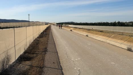 Ciclistas-Vestidos-De-Ciclista-Haciendo-Ejercicio-Diario-A-Lo-Largo-De-La-Carretera-Junto-Al-Acueducto-En-España