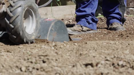 Farmer-man-driving-small-hand-tractor-for-soil-cultivation-to-prepare-soil-for-gardening