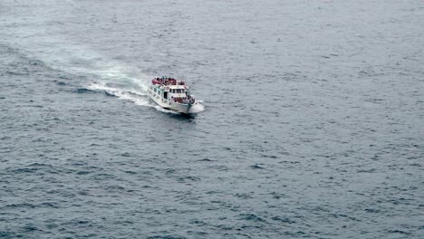 Tour-Boat,-Tourist-Sightseeing-Boat,-full-of-tourists-sailing-across-the-Cinque-Terre-sea,-Italy-coast