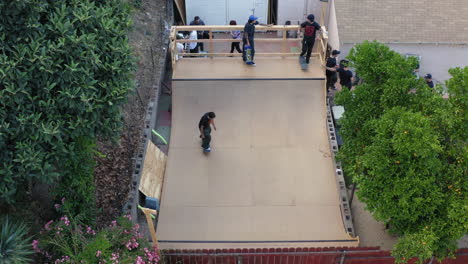 Patinadores-Montando-Tablas-En-La-Rampa-De-Patinaje-Del-Patio-Trasero-De-Los-ángeles,-Vista-Aérea