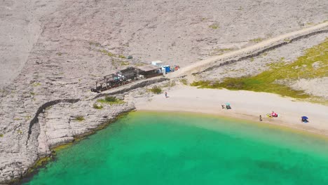 Toma-Panorámica-Desde-El-Bar-De-La-Playa-Hasta-El-Final-De-La-Playa-Aislada,-Isla-De-Pag