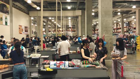 Clientes-Que-Pagan-En-El-Cajero-Con-Caja-Registradora-En-El-Mostrador-Del-Supermercado-Costco-Durante-La-Pandemia-De-Coronavirus-En-Tokio,-Japón