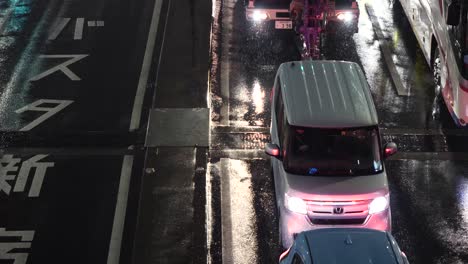 Close-up-of-cars-passing-below-a-bridge-on-a-rainy-night-in-Tokyo