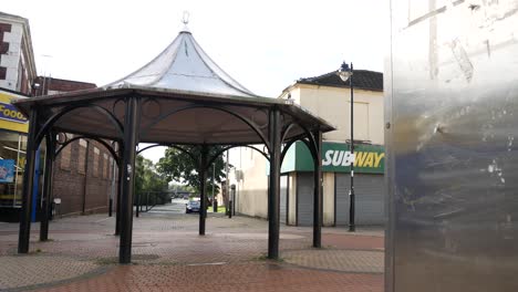 Town-bandstand-in-closed-urban-retail-stores-due-to-corona-virus-recession-reveal-from-behind-phone-booth