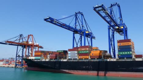 Side-view-of-a-large-cargo-ship-carrying-containers-in-the-port-of-Valencia,-Spain