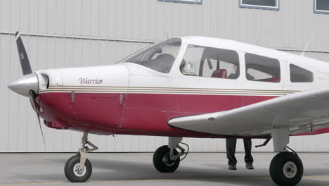 Adult-Male-Walking-Around-Small-Stationary-Airplane.-Static