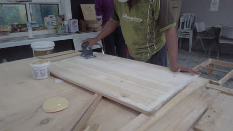 a-masked-man-using-wood-sanding-machine-in-a-slow-motion