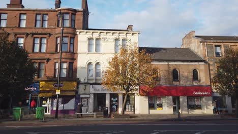 A-man-sits-on-a-bench-on-a-busy-Scottish-main-street