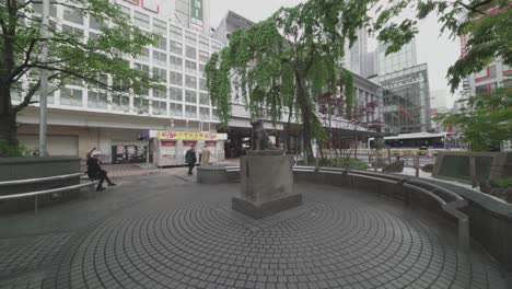 Few-People-Coming-To-Shibuya-Train-Station-Near-The-Famous-Hachiko-Statue-In-Tokyo,-Japan-Under-World-Lockdown---Coronavirus-Outbreak---Wide-Shot