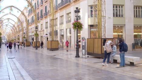 People-At-Calle-Larios-With-Christmas-Decoration-In-Malaga,-Spain---Christmas-During-Pandemic---panning-shot