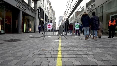 Low-angle-shot-of-fences-in-the-middle-of-the-Rue-Neuve-shopping-street-in-Brussels,-Belgium