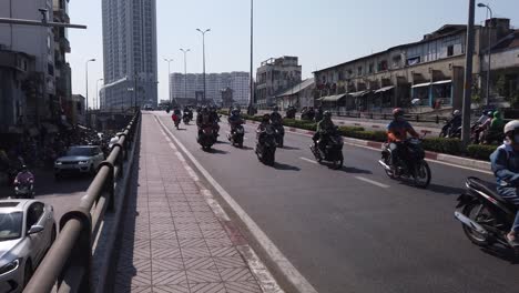 Vietnam,-Ciudad-De-Ho-Chi-Minh,-Busto-De-Tráfico-De-Motocicletas-En-Un-Puente-Con-Modernos-Edificios-De-Gran-Altura-Y-Un-Antiguo-Edificio-Coolonial-Francés-En-Un-Día-Soleado