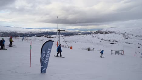 Children-skiing-and-snowboarding-downhill-from-Hangurstoppen-at-Voss-resort---Norway