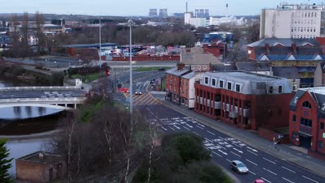 Aerial-view-looking-down-suburban-city-centre-streets-urban-infrastructure-traffic-low-descending-shot