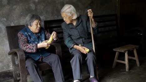 Zwei-Alte-Freundinnen-Teilen-Einen-Lustigen-Moment-Beim-Bananenessen