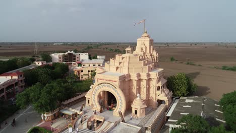 Toma-Aérea-Giratoria-Del-Templo-Palitana-Con-Campo-Vacío-En-El-Fondo