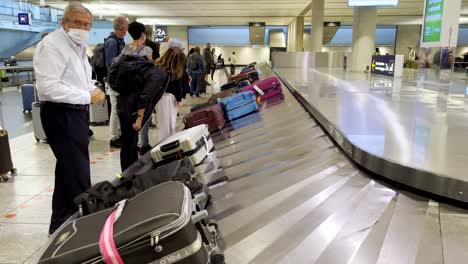 People-picking-up-their-bags-at-the-airport-carousel-baggage-claim