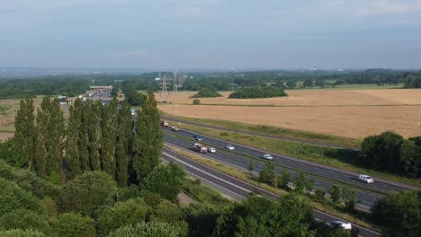 Vista-Aérea-Campo-Agrícola-Rural-Tierras-De-Cultivo-En-Rainhill-Y-Concurrido-Tráfico-De-La-Autopista-M62