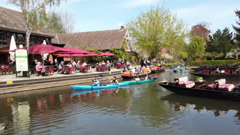 Paisaje-De-Bosque-Juerga-Con-Gente-En-Kayaks-Junto-Al-Restaurante-En-Lehde