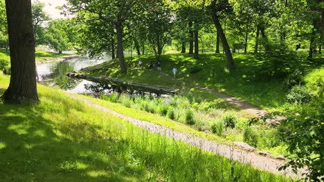 People-sitting-along-the-water-at-Deering-Oaks-Park-in-Portland,-Maine