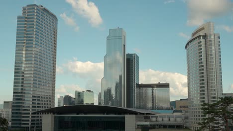 Weiße-Wolken-Ziehen-Vorbei-Und-Spiegeln-Sich-In-Den-Gläsernen-Wänden-Des-WTC-Seoul-Trade-Tower-Und-Des-Coex-Convention-And-Exhibition-Center,-Des-Intercontinental-Hotels-Und-Der-Gebäudefassaden-Des-Asem-Tower-–-Gangnam